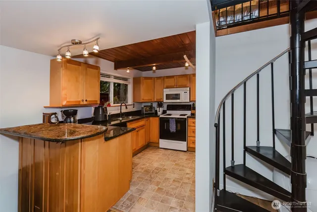 a kitchen with stainless steel appliances granite countertop a stove a sink and a microwave