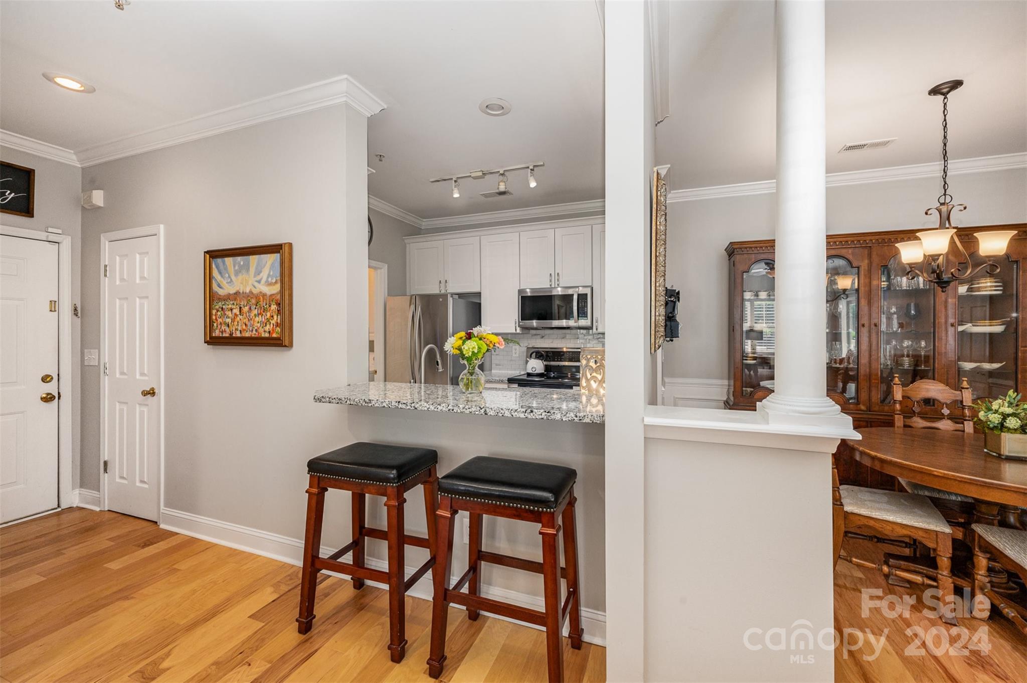 5730 Closeburn Road, Unit G Charlotte, NC 28210 - Photo 10 of 30 a kitchen with stainless steel appliances granite countertop a stove top oven a sink a dining table and chairs with wooden floor