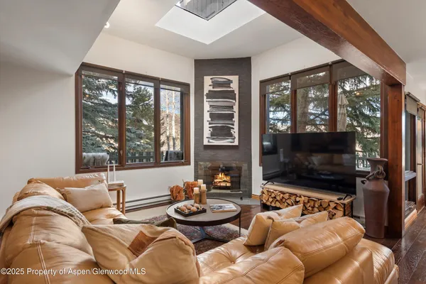 a living room with furniture a flat screen tv and a floor to ceiling window