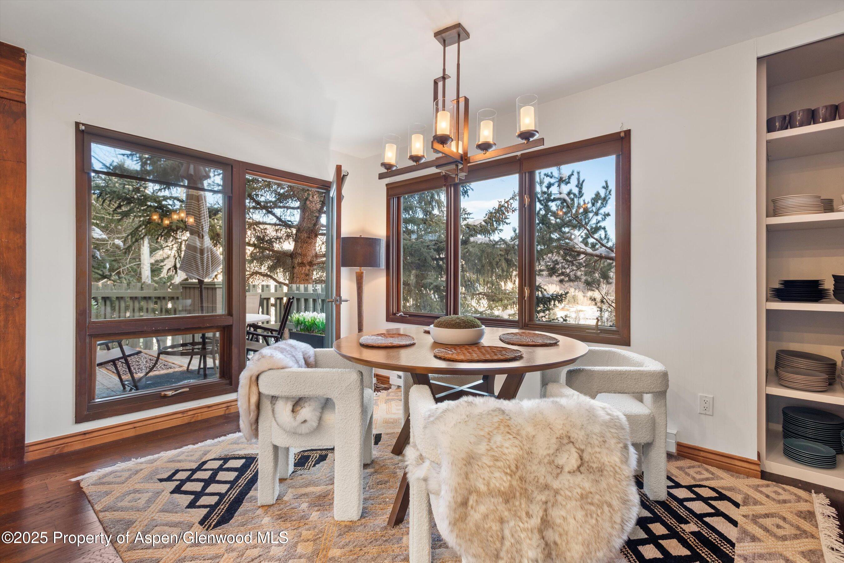 382 Meadow Ranch Road, Unit F4B Snowmass Village, CO 81615 - Photo 12 of 30 a view of a dining room with furniture large windows and wooden floor