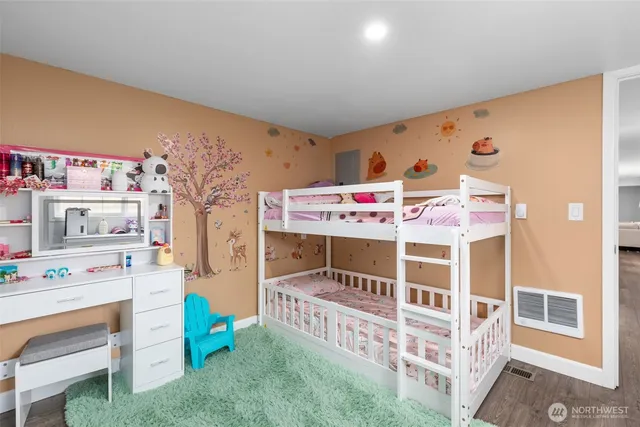 a room with baby crib and dresser