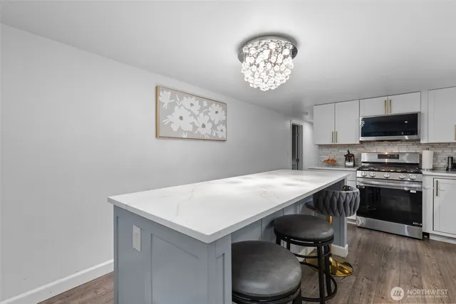 a kitchen with a cabinets a sink and a stove with wooden floor