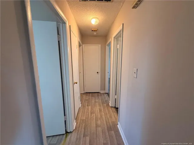 a view of hallway with wooden floor