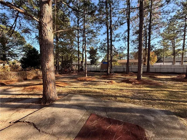a row of trees with side of house