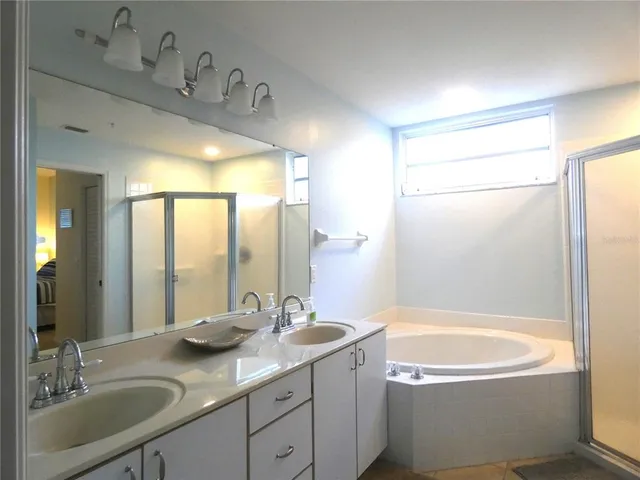 a bathroom with a granite countertop sink mirror bathtub and shower