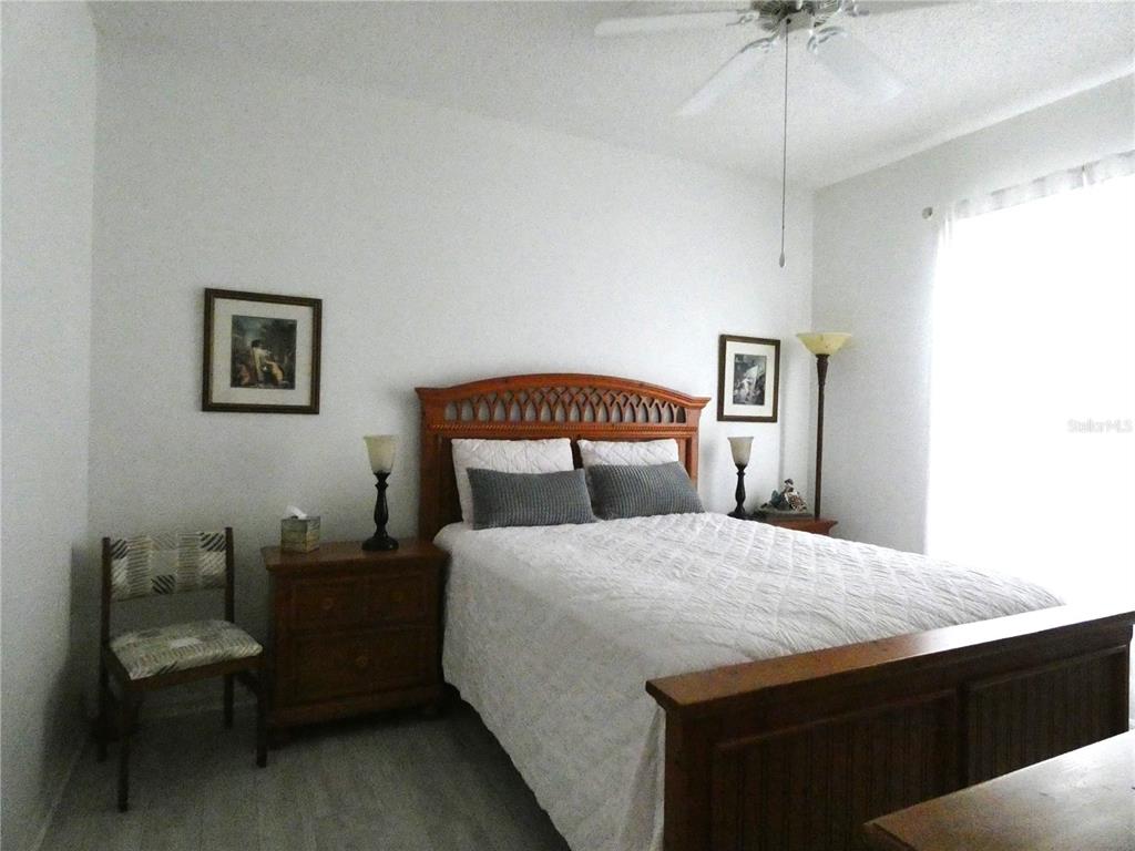 8901 Veranda Way, Unit 111 Sarasota, FL 34238 - Photo 19 of 41 a bedroom with a bed and a chandelier