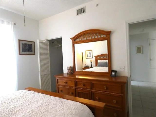 a bedroom with a bed and a mirror on dresser