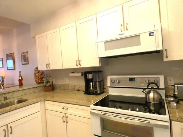 a kitchen with a stove and a white cabinets