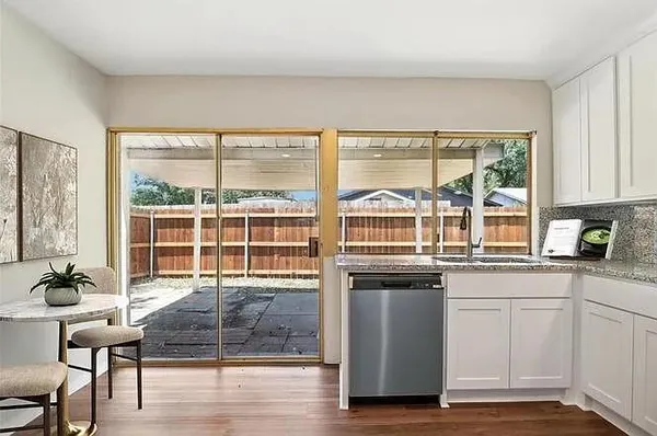 a kitchen with stainless steel appliances granite countertop a stove a sink and a granite counter tops with white cabinets
