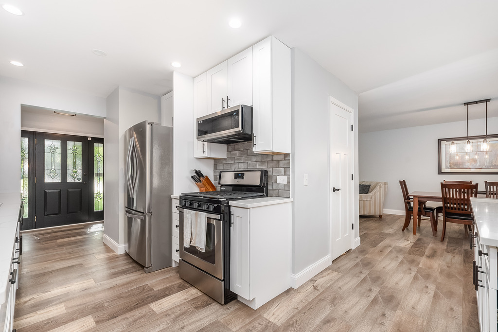 1570 Burning Trail Wheaton, IL 60189 - Photo 7 of 30 a kitchen with stainless steel appliances a stove a refrigerator a sink a dining table and chairs with wooden floor