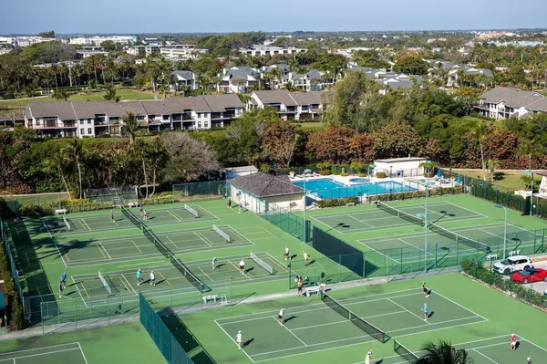 an aerial view of a tennis ground and residential houses