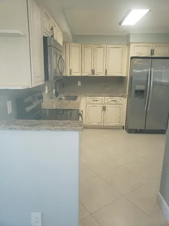 a kitchen with a sink a refrigerator and cabinets