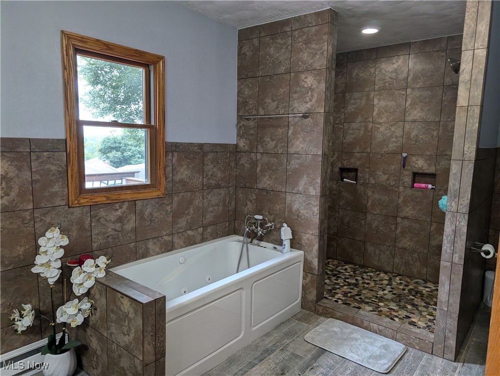 46136 Carlisle Road Lisbon, OH 44432 - Photo 39 of 48 Bathroom with tile walls, separate shower and tub, and hardwood / wood-style floors