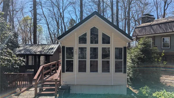 a view of wooden house with a small yard