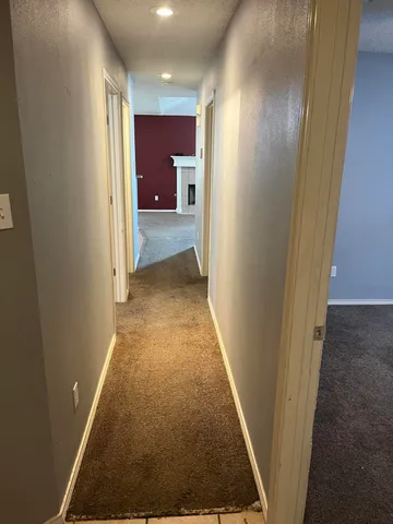 a view of a hallway with a livingroom and a bathroom