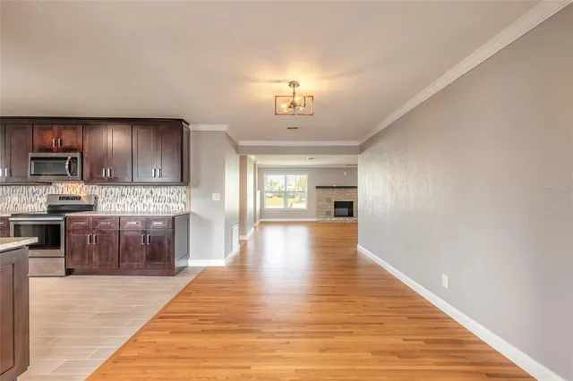 a large kitchen with cabinets wooden floor and stainless steel appliances