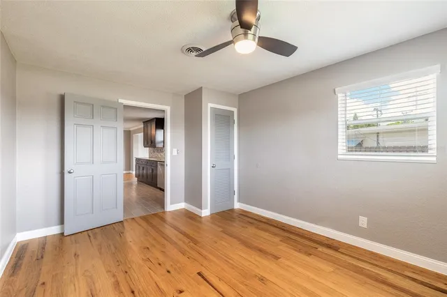 a view of empty room with wooden floor