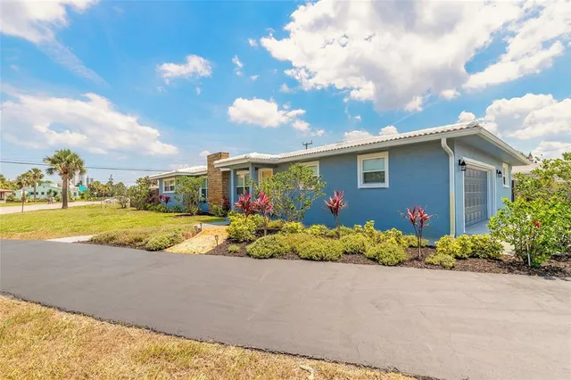 a view of a house with a yard and potted plants
