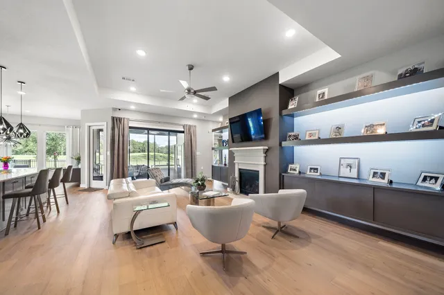 a living room with furniture a fireplace and a large window