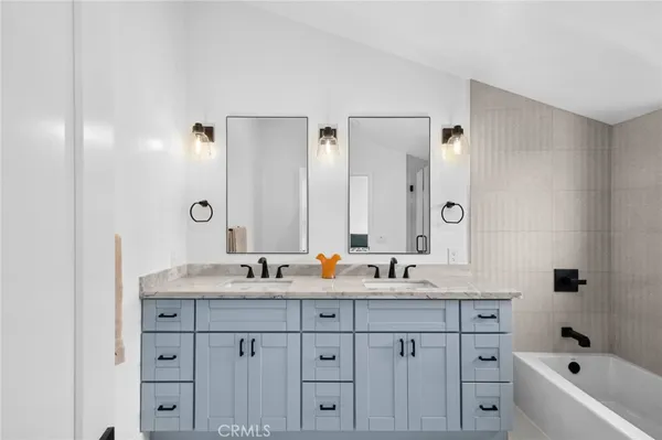 a bathroom with double sink and a mirror