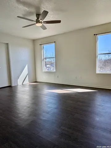 a view of a livingroom with wooden floor and a ceiling fan