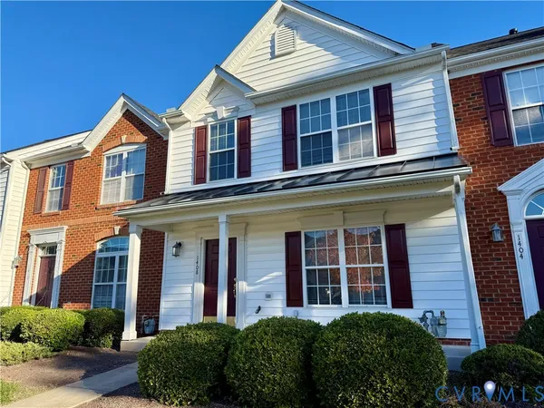 front view of a brick house with a small yard