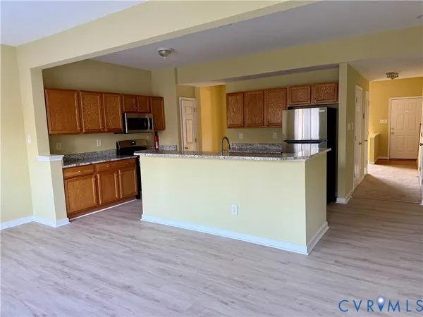 a kitchen with stainless steel appliances granite countertop a stove top oven a sink dishwasher and a refrigerator