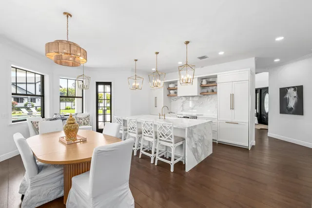 a very nice looking room with kitchen island furniture a large window and a chandelier