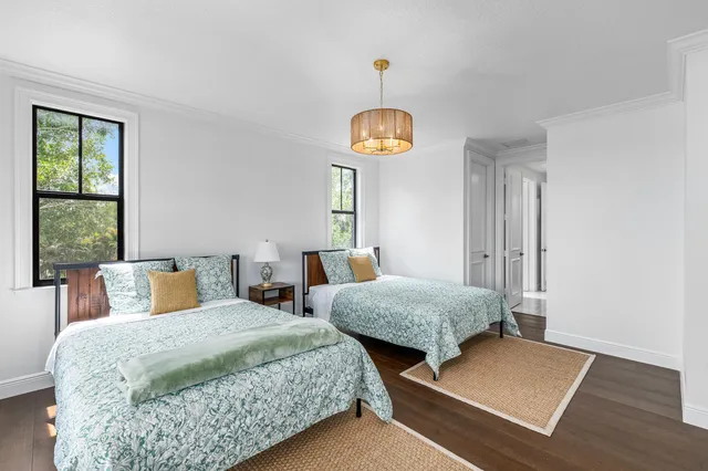 a bedroom with two beds and a chandelier