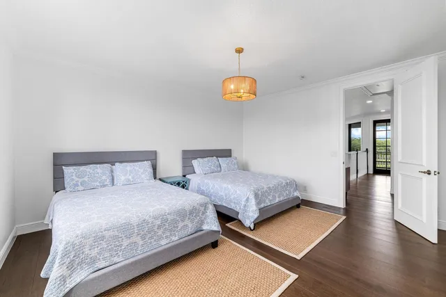 a spacious bedroom with a bed and wooden floor