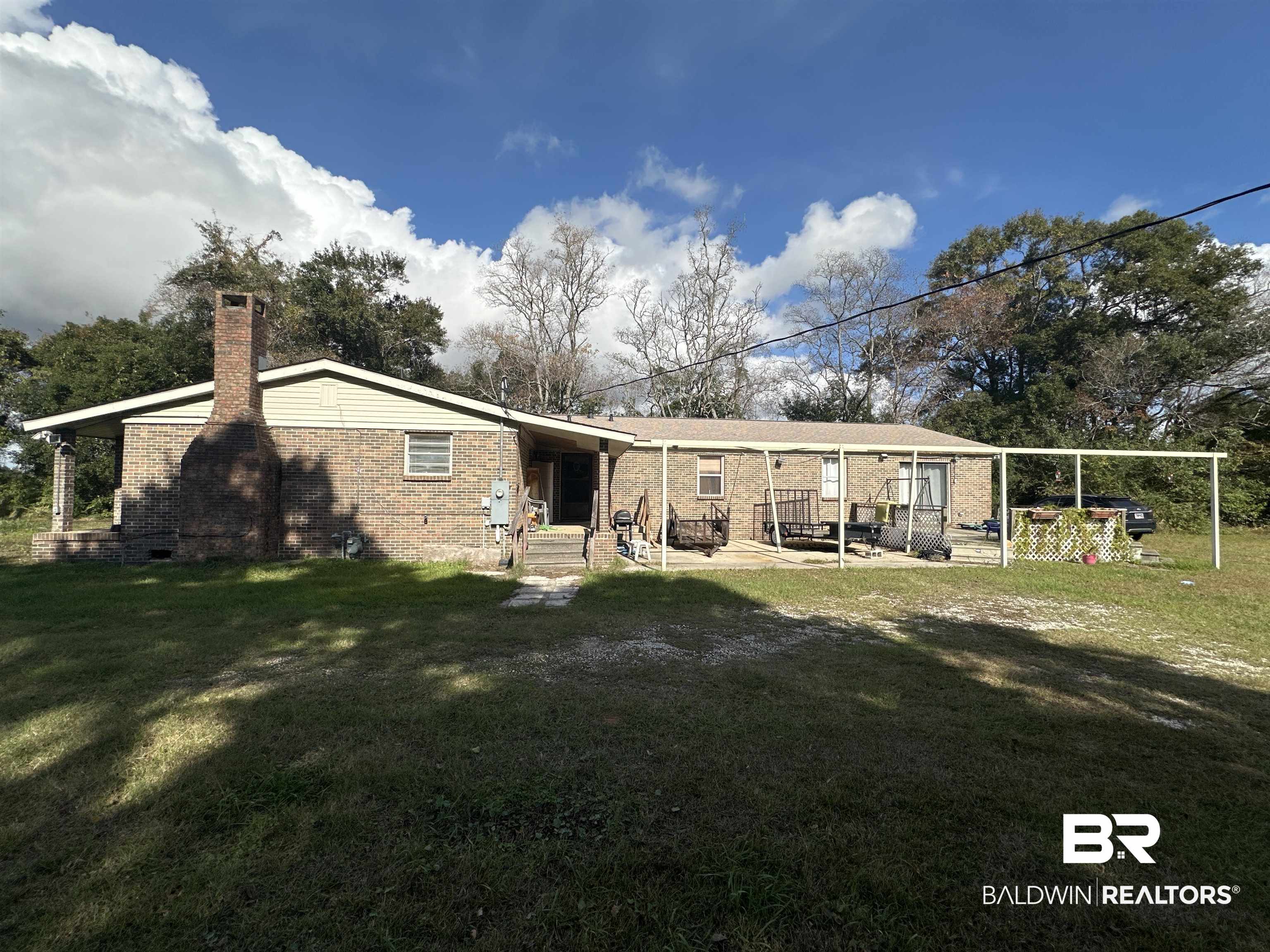 9520 C Four Mile Road Irvington, AL 36544 - Photo 29 of 32 Rear view of property with a lawn