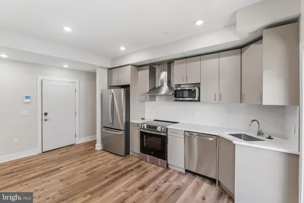 a kitchen with stainless steel appliances granite countertop a refrigerator and a sink