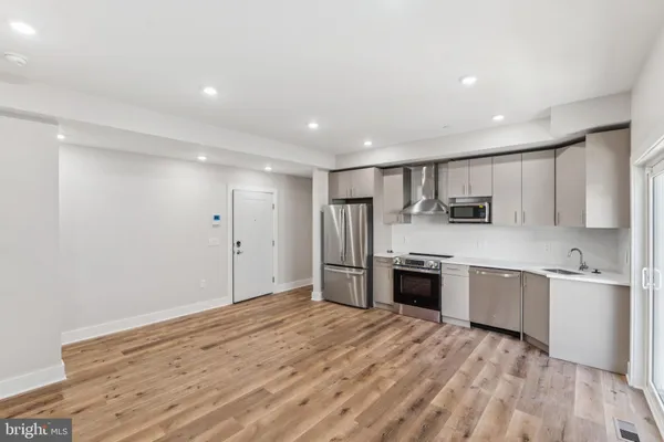 a large kitchen with stainless steel appliances granite countertop a stove and a refrigerator