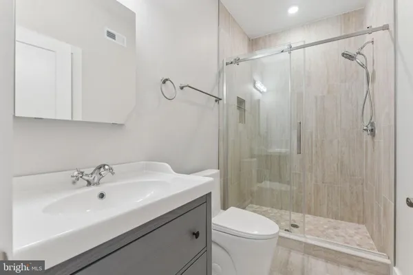 a bathroom with a sink a toilet and shower