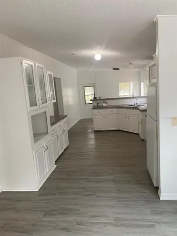 a view of a kitchen with wooden floor and electronic appliances