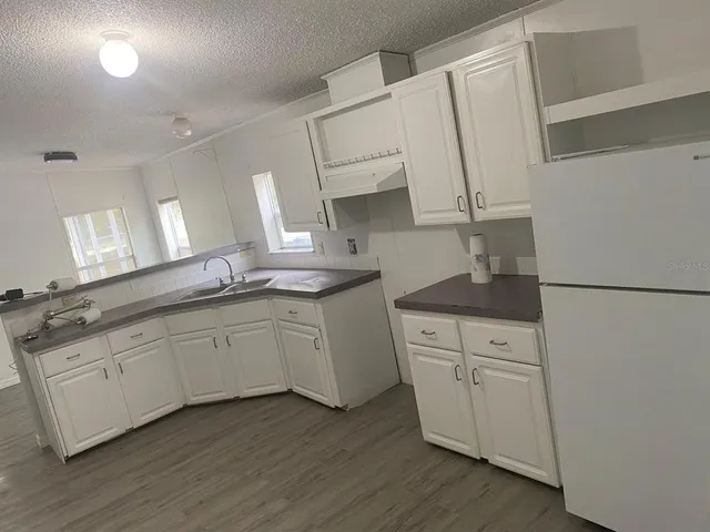 a kitchen with granite countertop white cabinets and white appliances