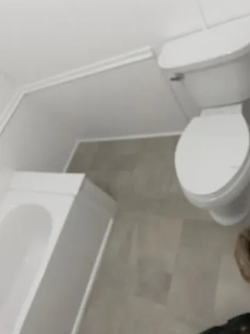 a bathroom with a toilet and a view of bathroom