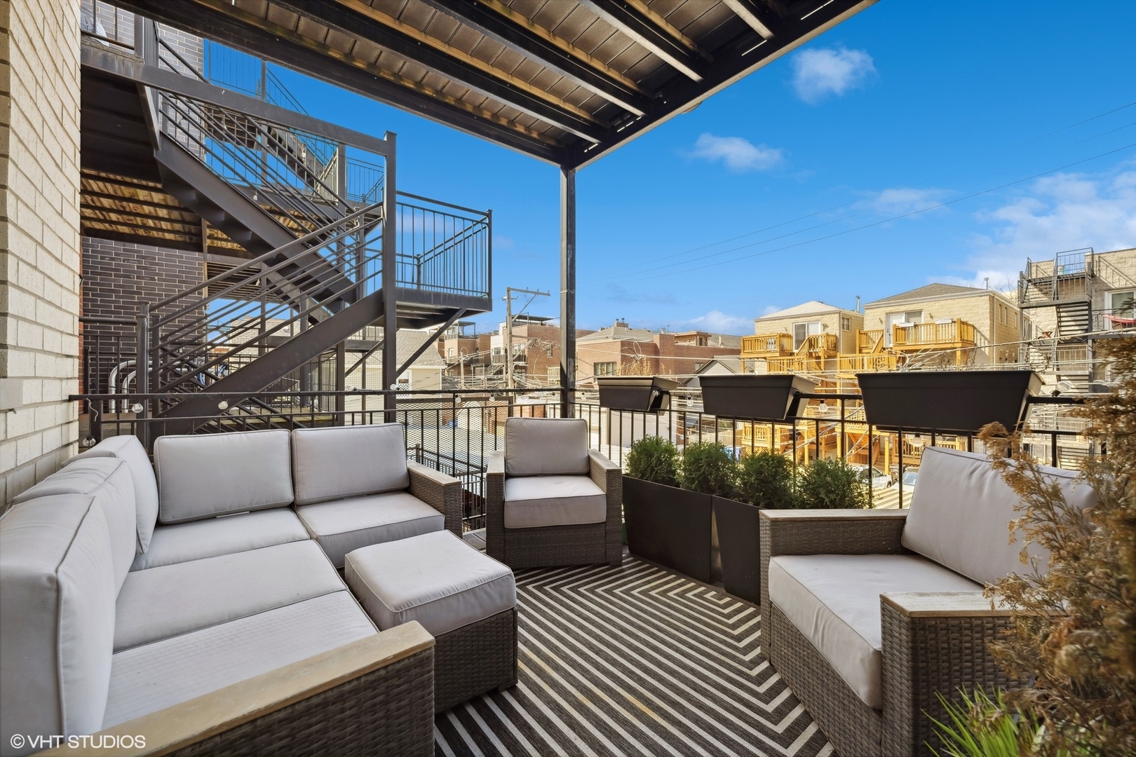 1448 West Chestnut Street, Unit 2 Chicago, IL 60642 - Photo 19 of 20 a balcony with wooden floor and outdoor seating