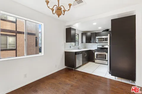 a kitchen with stainless steel appliances a refrigerator sink and cabinets