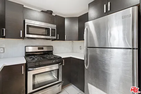 a kitchen with cabinets and steel stainless steel appliances
