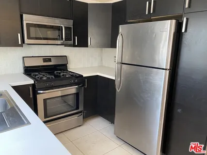 a kitchen with stainless steel appliances a refrigerator stove and microwave