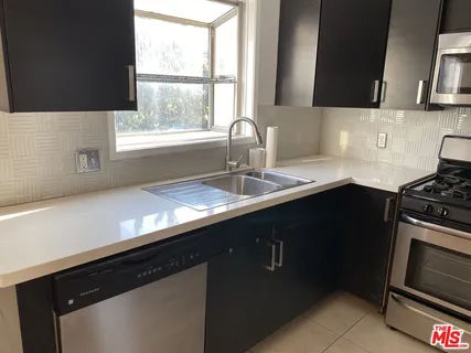 a kitchen with a sink a stove and a microwave