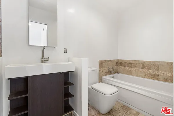 a bathroom with a sink toilet a mirror and bathtub