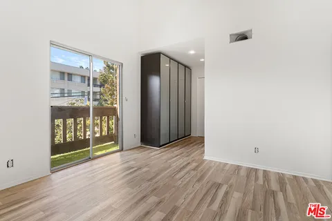 an empty room with wooden floor and door