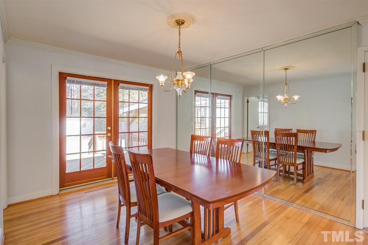 3424 Wade Avenue Raleigh, NC 27607 - Photo 8 of 30 a dining room with wooden floor a chandelier a glass table and chairs