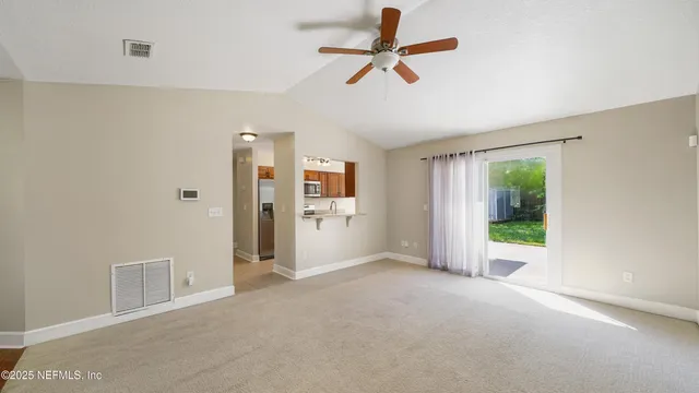 a view of a livingroom with a ceiling fan & entryway