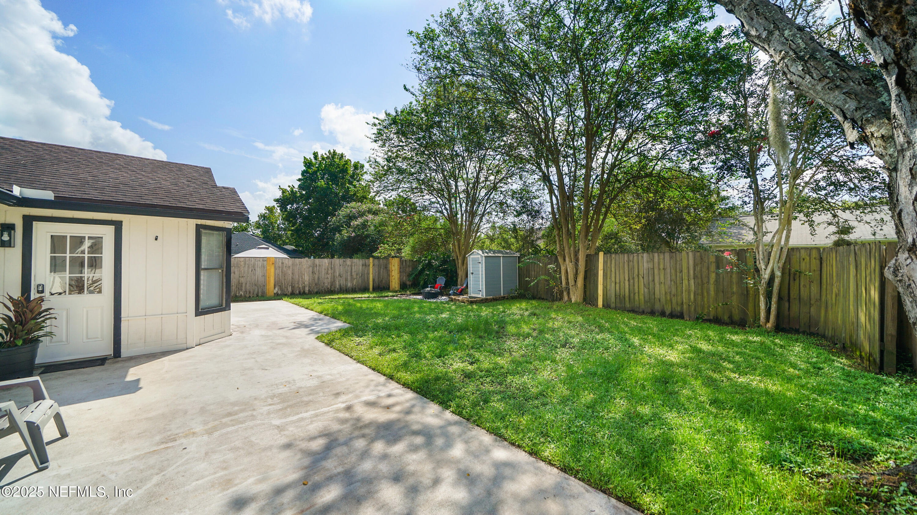 3255 Dowitcher Lane Orange Park, FL 32065 - Photo 23 of 27 a view of a backyard with large trees and wooden fence