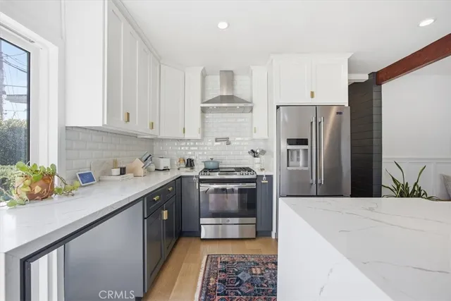 a kitchen with stainless steel appliances a sink a stove a refrigerator cabinets and a counter top space