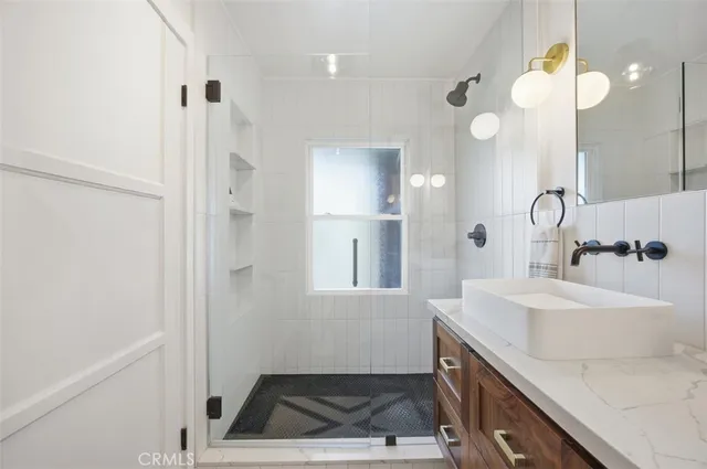 a bathroom with a sink a toilet a mirror and shower