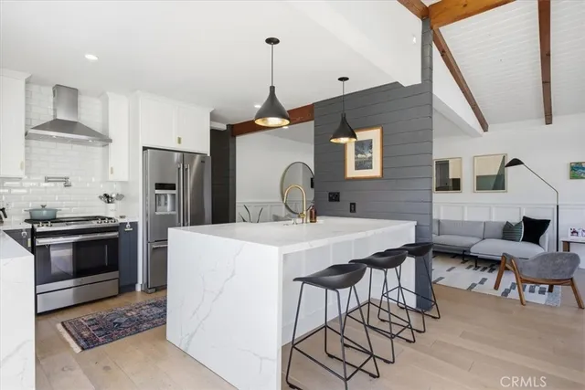 a kitchen with stainless steel appliances granite countertop a sink a stove and refrigerator